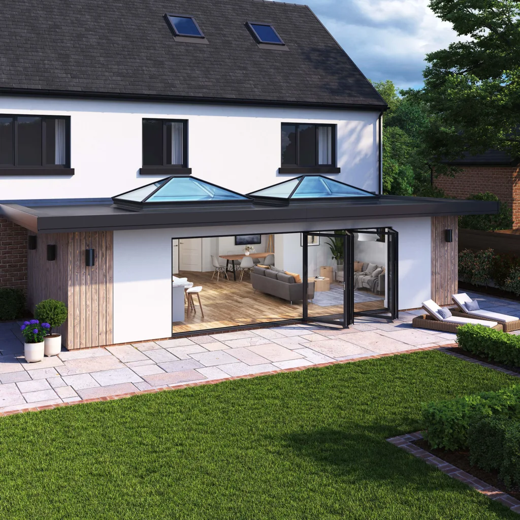 Daytime exterior view of a home extension featuring two Korniche Roof Lanterns and a fully open Korniche Bifold Door leading to a patio and garden.