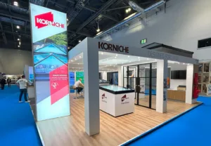 The full Korniche exhibition stand at the Homebuilding Show, displaying the Roof Lantern, Flat Glass, and Glass Partition with the "Award Winning Aluminium Glazed Solutions" sign.
