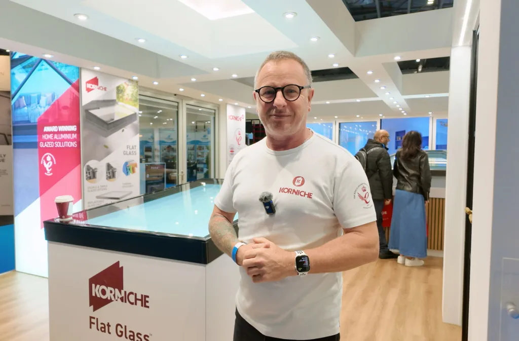 Korniche Brand Ambassador Mark Millar standing next to the Korniche Flat Glass rooflight while wearing a branded T-shirt.