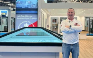 Mark Millar standing beside Korniche roof lantern at NEC show