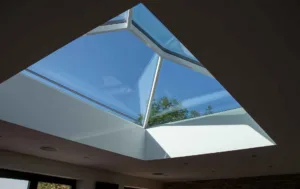 Interior view looking up through a white Korniche Roof Lantern towards a clear blue sky.