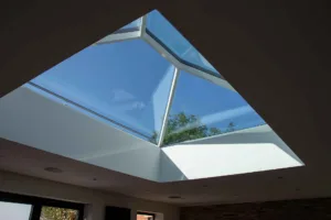 Interior view looking up through a white Korniche Roof Lantern towards a clear blue sky.
