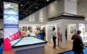 Wide shot of the busy Korniche Stand F101 showcasing aluminium home products, bi-fold doors, and roof lanterns at ExCeL London 2026.
