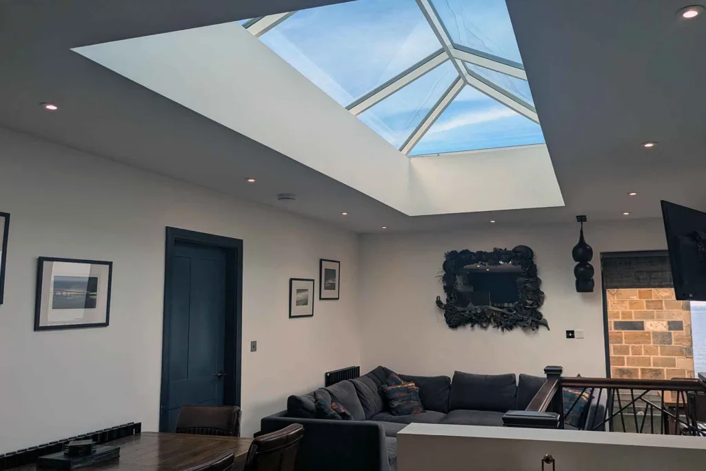 Large Korniche roof lantern in an open-plan coastal living room and dining area overlooking the sea